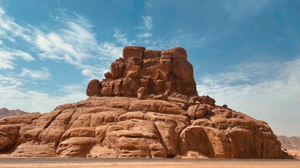 a large rock formation with Bell Rock in the background